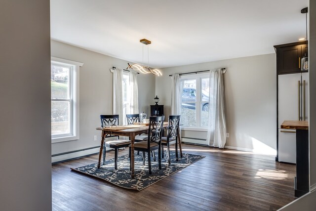 dining room with an inviting chandelier, dark wood-type flooring, a wealth of natural light, and baseboard heating