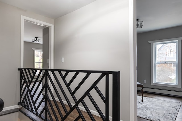 stairs featuring a baseboard radiator and hardwood / wood-style floors