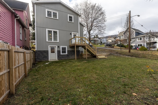 back of house featuring a deck and a lawn