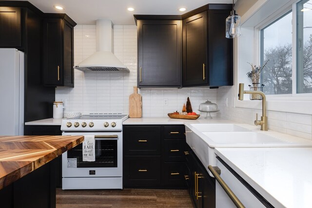 kitchen featuring white appliances, decorative light fixtures, decorative backsplash, and wall chimney exhaust hood