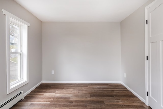 empty room with dark hardwood / wood-style flooring and baseboard heating