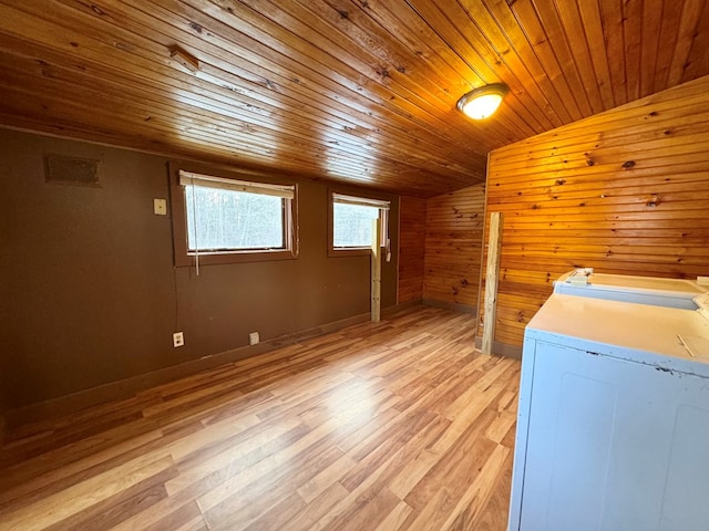 laundry room with wooden walls, wood ceiling, and light wood-type flooring