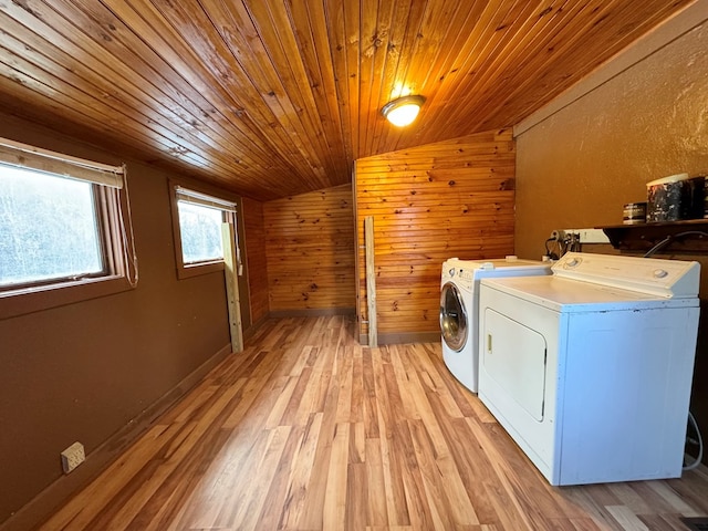 laundry room featuring separate washer and dryer, wood ceiling, wooden walls, and light wood-type flooring