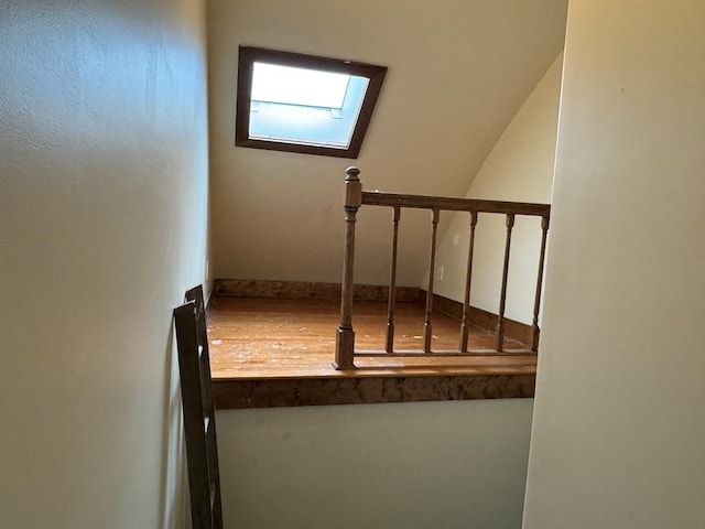 staircase with wood-type flooring and a skylight