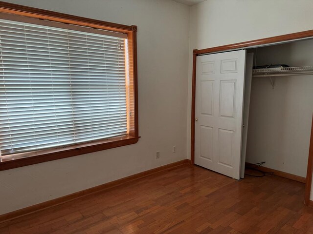 unfurnished bedroom featuring hardwood / wood-style floors and a closet