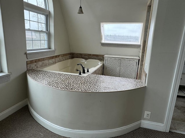 bathroom with a washtub and tile patterned floors