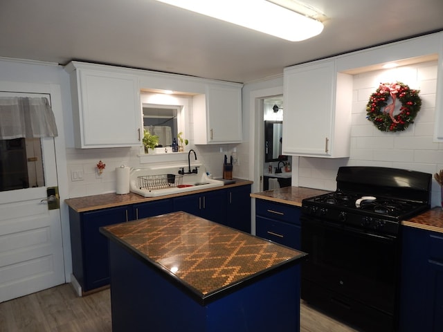 kitchen with blue cabinets, a center island, black gas range oven, and white cabinets