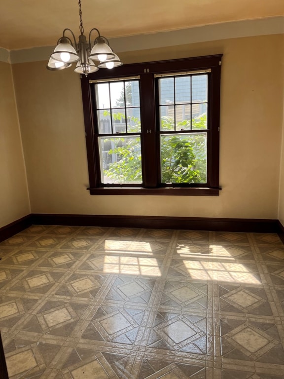 empty room with a wealth of natural light and a chandelier