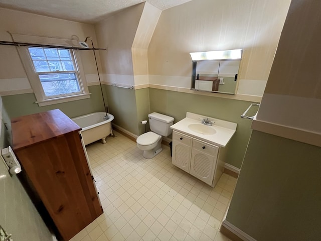 bathroom featuring a washtub, vanity, and toilet