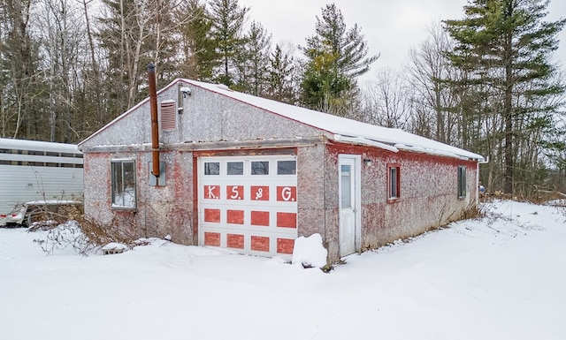 view of snow covered exterior with a garage