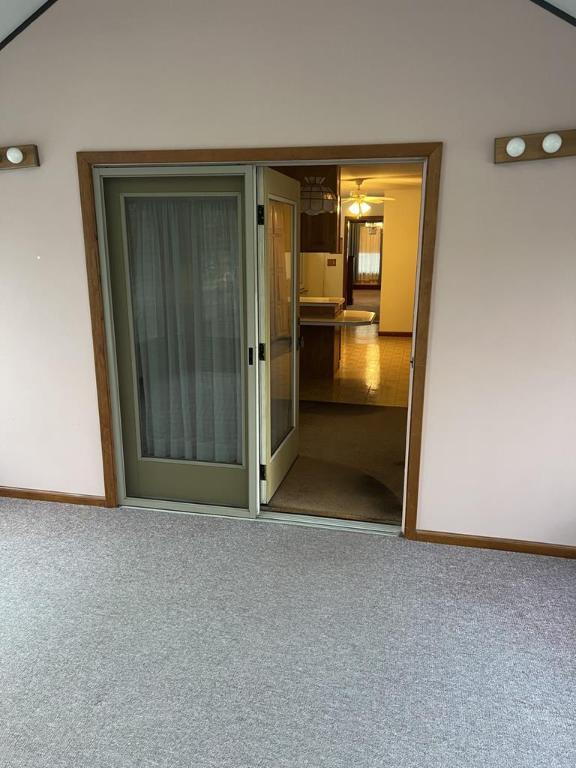 carpeted empty room with lofted ceiling