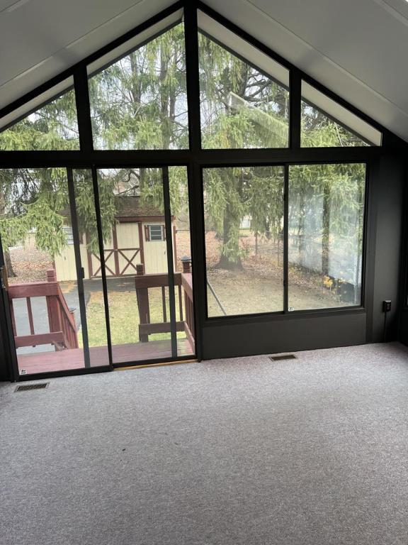 interior space with carpet flooring and vaulted ceiling