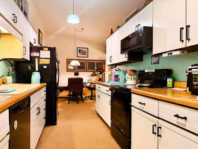 kitchen with pendant lighting, sink, lofted ceiling, white cabinetry, and black appliances