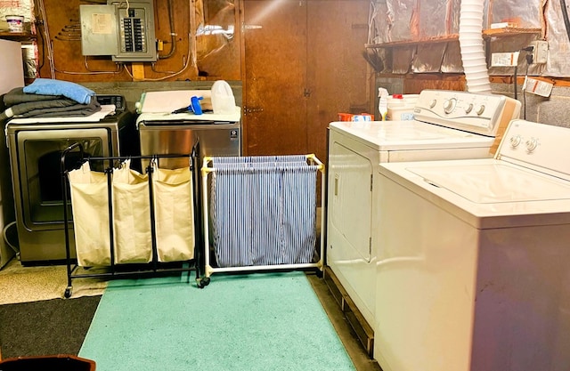 clothes washing area with electric panel and washer and dryer