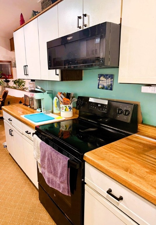 kitchen featuring butcher block countertops, black appliances, and white cabinets