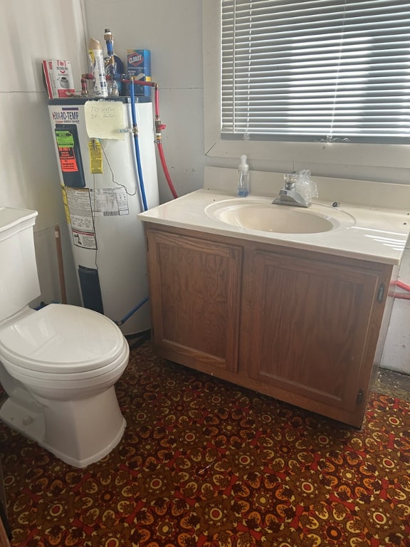 bathroom with vanity, toilet, and electric water heater