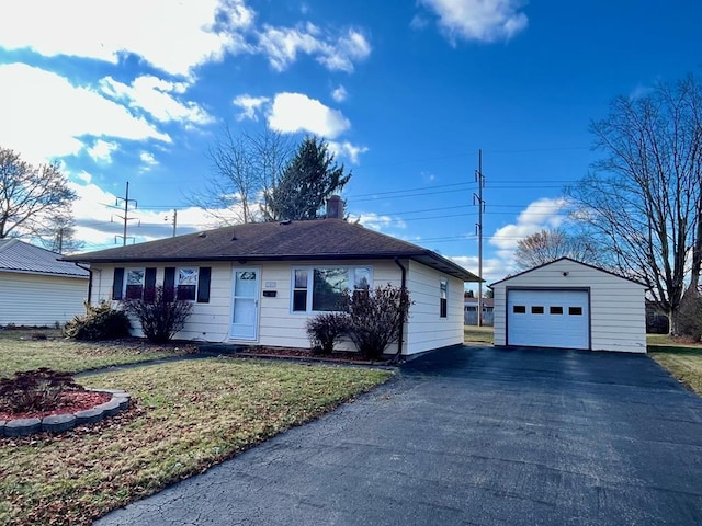 single story home featuring a garage, an outdoor structure, and a front lawn