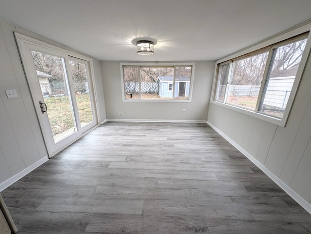 unfurnished dining area with hardwood / wood-style floors and plenty of natural light