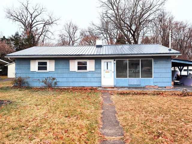 ranch-style home featuring a front lawn and a carport