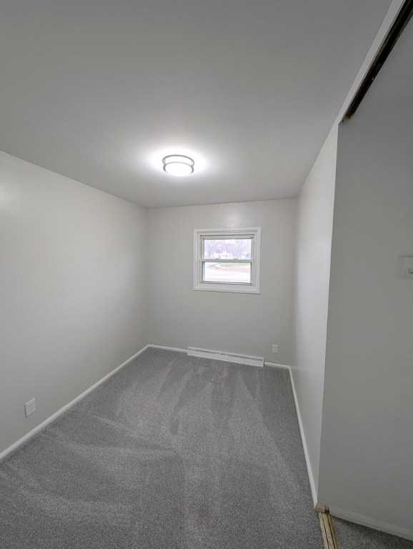 spare room with carpet flooring and baseboard heating