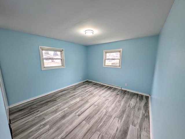 empty room with hardwood / wood-style flooring and a wealth of natural light