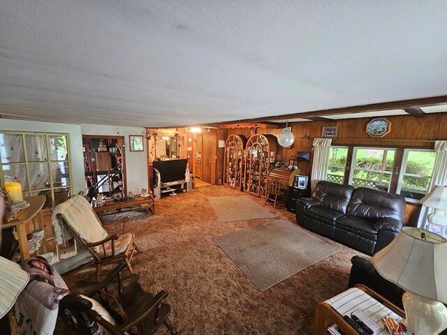 living room featuring carpet floors, a textured ceiling, and wood walls