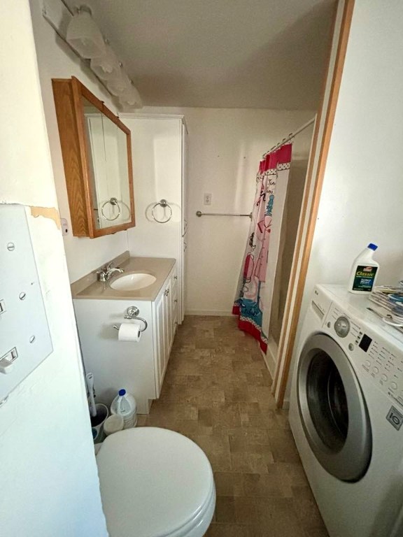 bathroom with vanity, washer / clothes dryer, toilet, and a shower with shower curtain