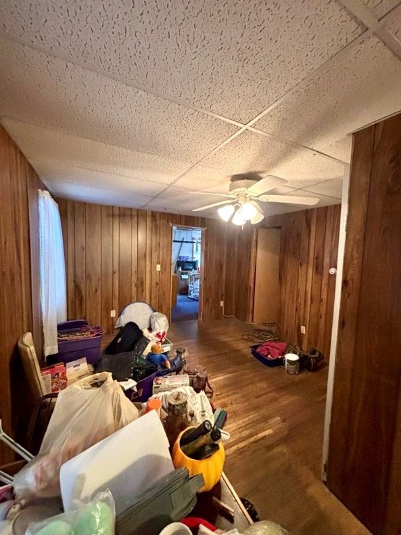 interior space with wooden walls, wood-type flooring, and a paneled ceiling