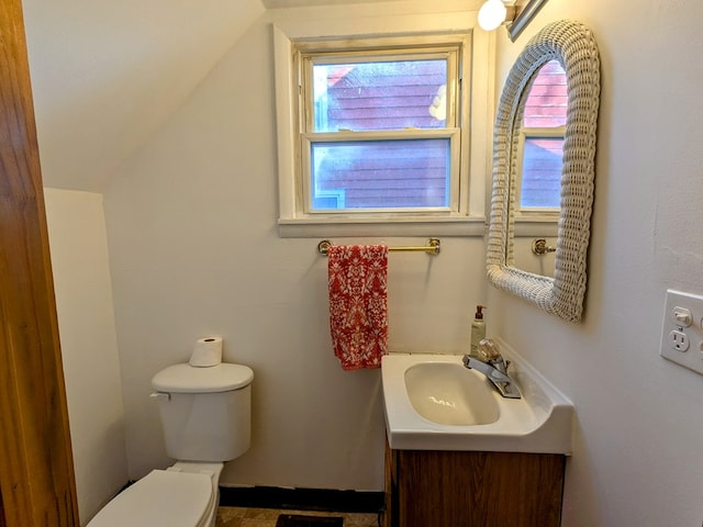 bathroom featuring vanity, vaulted ceiling, and toilet