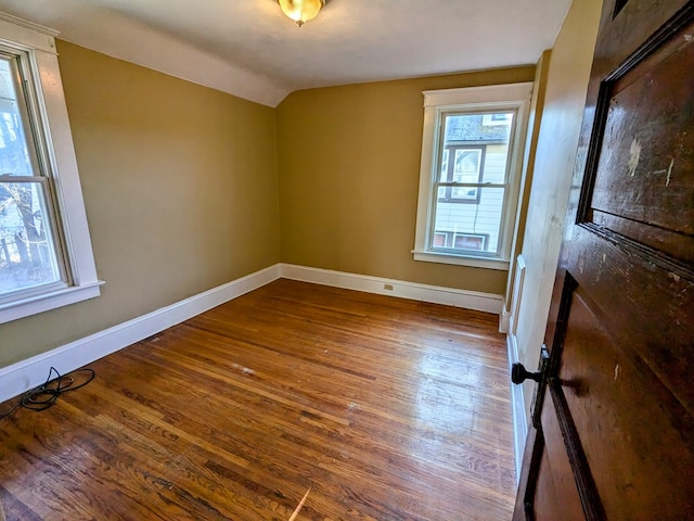 empty room featuring vaulted ceiling and wood-type flooring