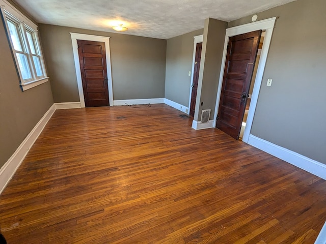 empty room featuring dark hardwood / wood-style floors and a textured ceiling