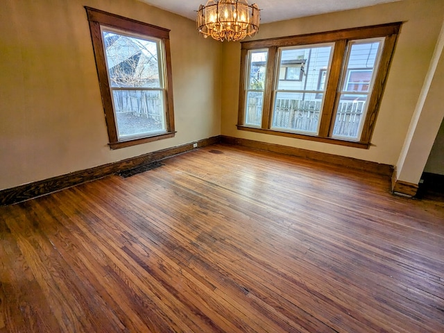 unfurnished dining area featuring dark wood-type flooring and a chandelier