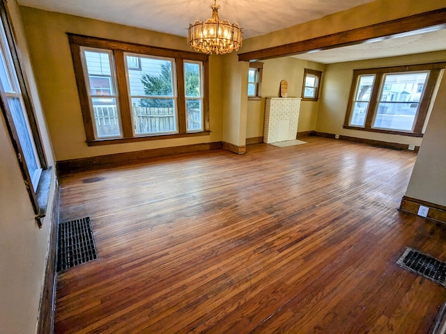 unfurnished living room featuring dark hardwood / wood-style flooring and a notable chandelier