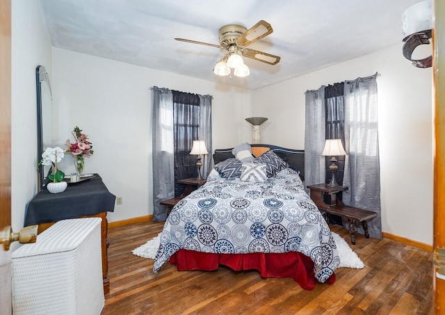 bedroom with dark hardwood / wood-style flooring and ceiling fan