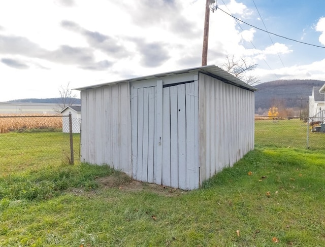 view of outbuilding featuring a rural view and a yard