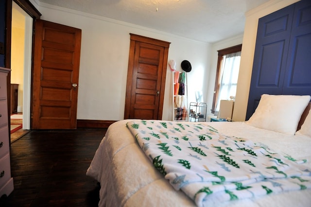 bedroom with ornamental molding and dark wood-type flooring