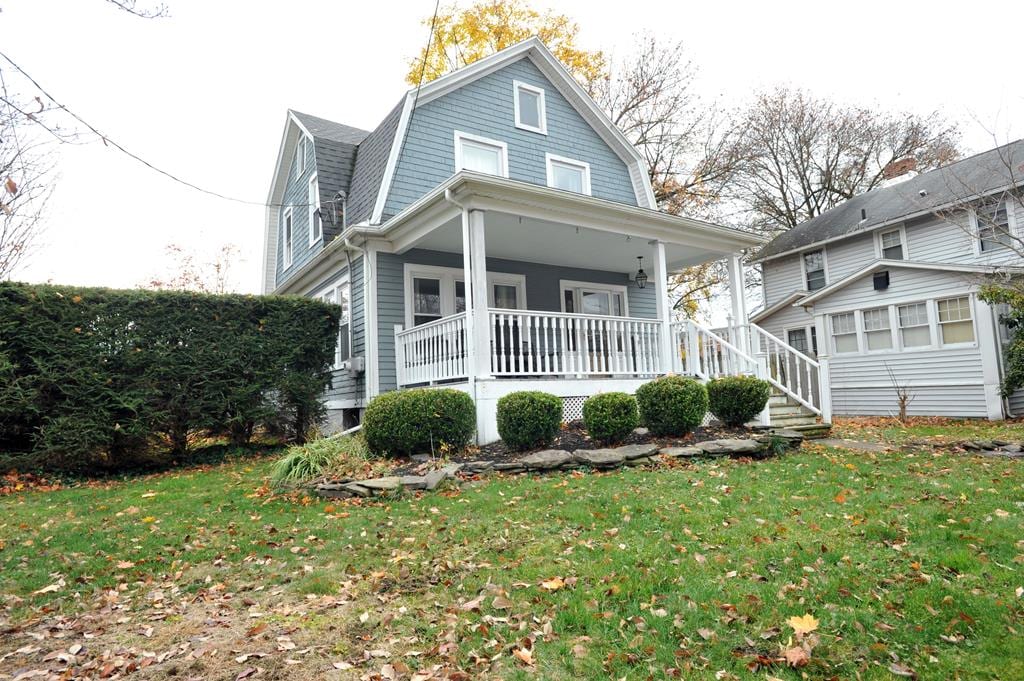 view of front of house featuring a porch and a front lawn