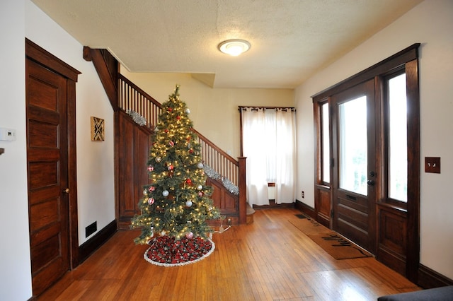 entrance foyer with hardwood / wood-style floors and a textured ceiling