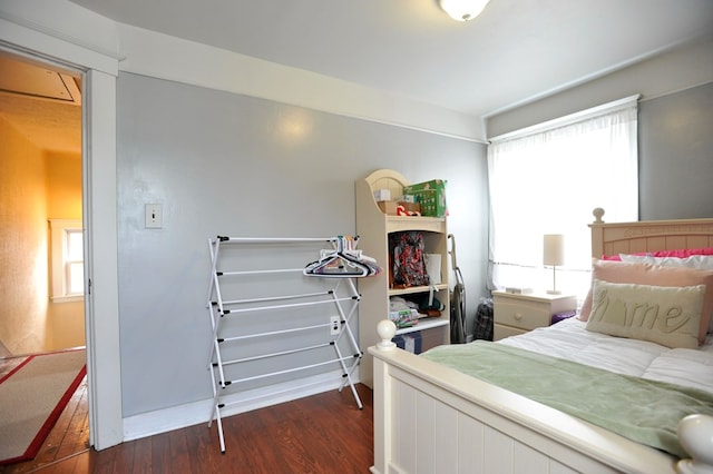 bedroom with multiple windows and dark wood-type flooring