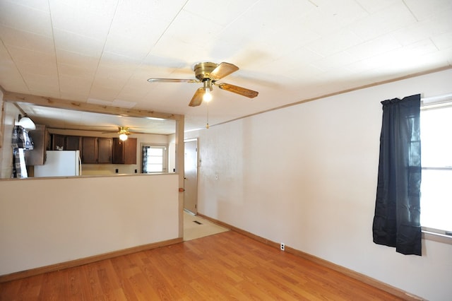 unfurnished living room featuring ceiling fan and light hardwood / wood-style floors