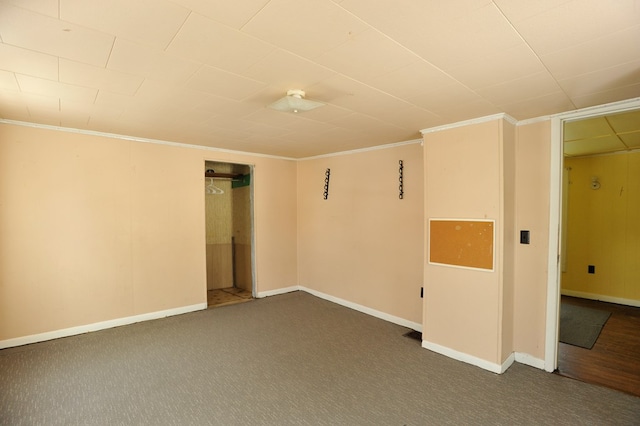 unfurnished room featuring crown molding and dark carpet