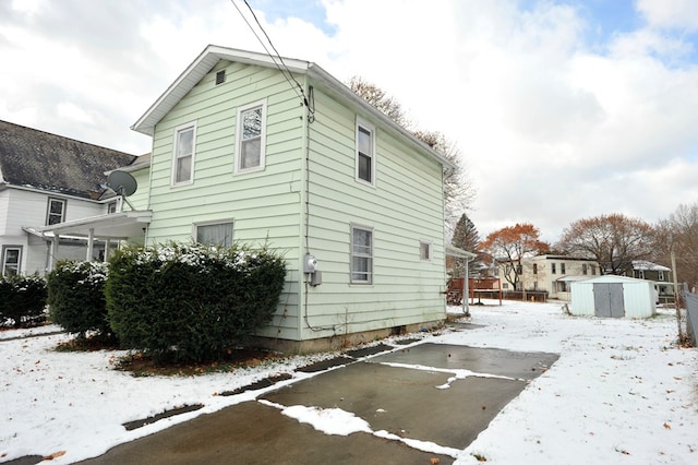 view of snow covered exterior featuring a shed