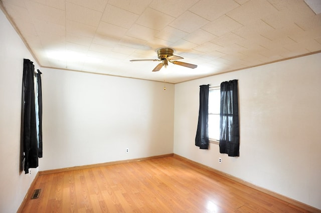 empty room with crown molding, ceiling fan, and light hardwood / wood-style flooring