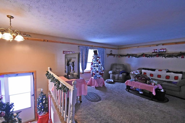 playroom featuring carpet floors, a textured ceiling, and a notable chandelier