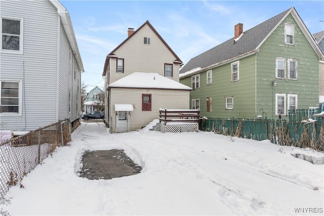 snow covered rear of property featuring a deck