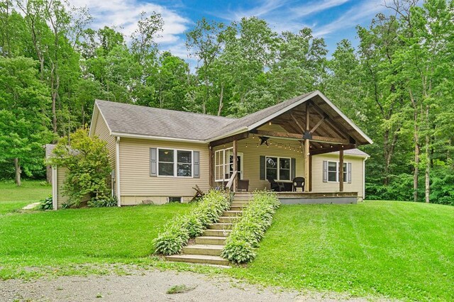 view of front of house with ceiling fan, a porch, and a front lawn