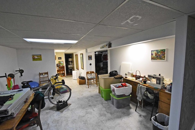 home office with concrete flooring and a paneled ceiling