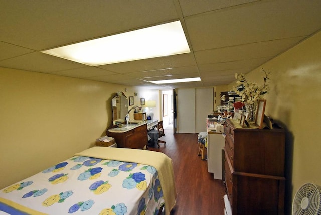 bedroom featuring a paneled ceiling and dark hardwood / wood-style flooring