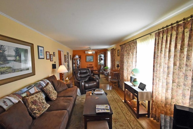 living room featuring wood-type flooring, ornamental molding, and ceiling fan