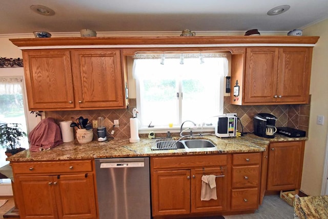 kitchen with light stone countertops, dishwasher, sink, and decorative backsplash